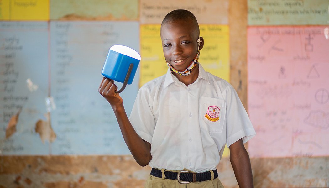 A Boy Smiles as His Picture Is Taken with a New Solar Lantern