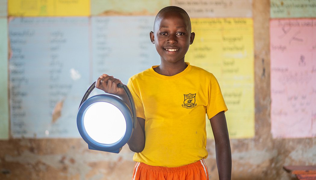 A Student Smiles Holding a New Solar Lantern