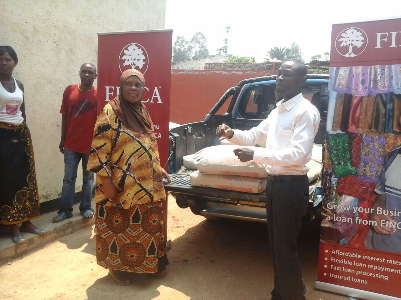 Marketing Manager donating bags of cement to a Chemusa Client (on the left of the pic) whose house got burnt(1)