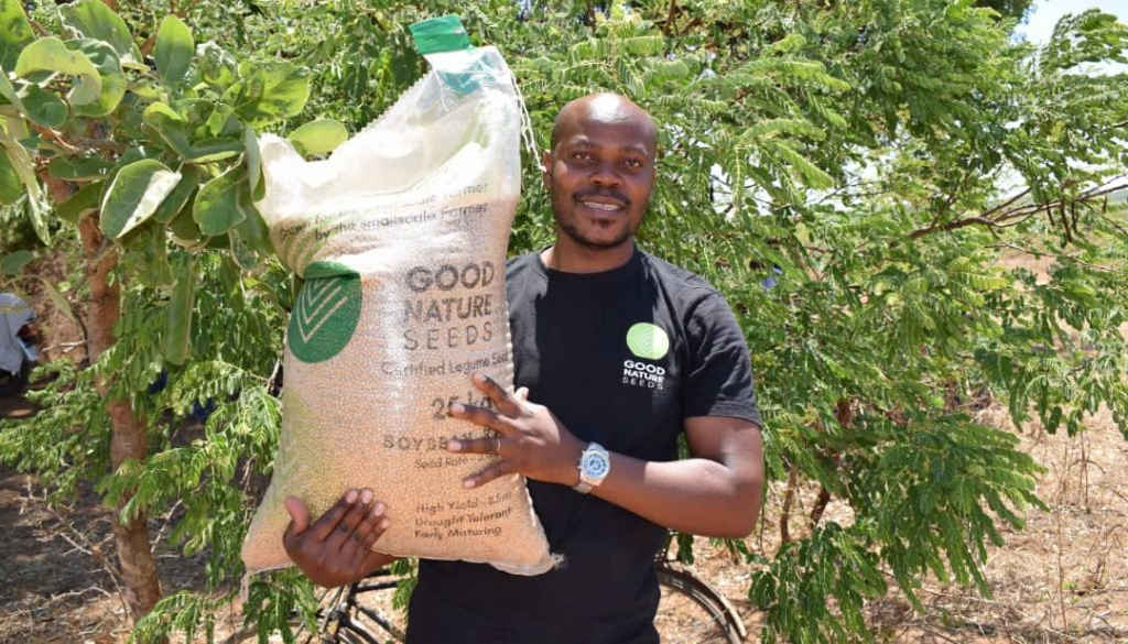 A Good Nature Agro employee holding a bag of improved seed stock.