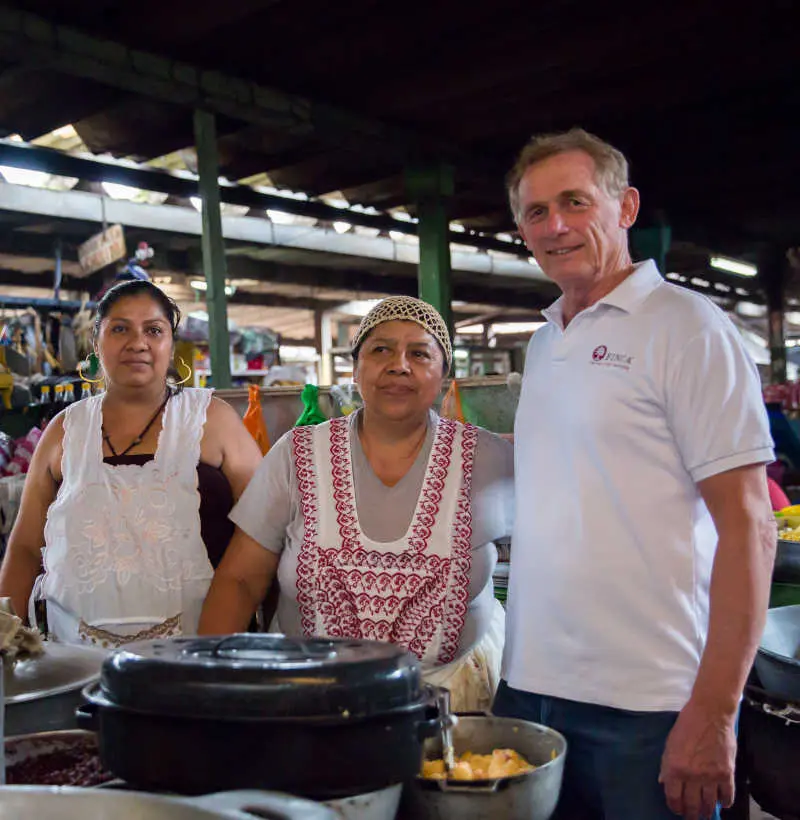Rupert stands with FINCA client Juana Cano at her business in Nicaragua.