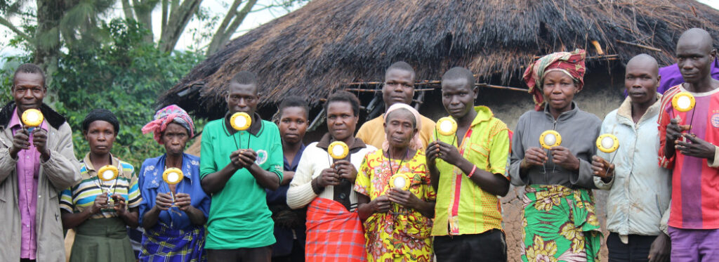 Members of the Akokoro VSLA organized by WINEPS hold the solar lanterns that they purchased. The members say that the lanterns provide "good light."